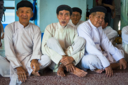 Cao Đài devotees sitting in the enclave of the Holy See at Tay Ninh prior to the start of the midday service. Photo: Julian Tennant