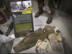 Sleeve from the jacket worn by Pfc. Jack N. "Hawkeye" Womer, one of the legendary 'filthy 13' of HQ Co. 506 PIR. The signalling 'cricket' (no.2) also belonged to Womer, whilst the glove belonged to another member of the 'filthy 13, Pfc. John Agnew. Photo: Julian Tennant US Paratrooper's D-Day Experience Museum. Saint-Côme-du-Mont, Normandy