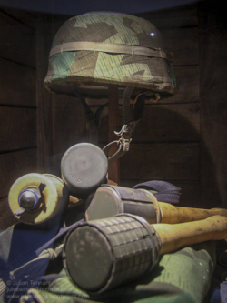 German paratrooper helmet and stick grenades on display at Dead Man's Corner Museum, Normandy, France. Photo: Julian Tennant 'Dead Man’s Corner' - German Paratrooper Museum – Saint-Côme-du-Mont, Normandy