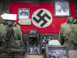 American uniforms and captured flag on display at Dead Man's Corner Museum, Normandy, France. Photo: Julian Tennant 'Dead Man’s Corner' - German Paratrooper Museum – Saint-Côme-du-Mont, Normandy