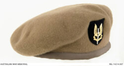 SASR beret : Trooper D R Barnby, 2 Squadron, Special Air Service Regiment.
Special Air Service Regiment fawn coloured wool beret, with gilded metal badge. The badge is superimposed on a black shield shaped felt patch. The badge is a silver dagger with gilded wings, superimposed with a gilded banner reading 'WHO DARES WINS'. The beret has four cotton reinforced ventilation eyelets, and is lined with black cotton fabric. The headband is made of sandy coloured synthetic material. The drawstring has been removed and replaced with a decorative bow. A maker's label marked 'SIZE 7' is sewn into the lining, and another label '217585 BARNBY, 2 SQN' is sewn into the left hand side.
Maker: Beret Manufacturers Pty Ltd
Place made: Australia: Victoria
Date made: 1967
AWM Accession Number: REL/14214.007 SASR Don Barnby Vietnam SAS