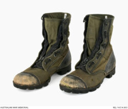 United States experimental tropical pattern boots : Trooper D R Barnby, 2 Squadron, Special Air Service Regiment.
Description: Pair of experimental United States Army tropical boots. The black leather nose caps of both boots are heavily worn, exposing raw leather. The heel of each boot is also black leather. The body and tongue of each boot consists of olive green nylon. A large metal and black nylon zip secures the boots. A vertical lacing system is a feature of the boots, incorporating eighteen metal eyelets per boot and black nylon cord. There are a pair of circular brass eyelets on the inside arch of each boot, for removing excess water. The soles of both boots are black rubber which are worn from use.
AWM Accession Number: REL/14214.003 SASR Don Barnby Vietnam SAS
