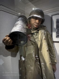 An artilleryman from the 969th Field Artilley Battalion carries a155mm shell for the M1 Howitzer. The soldier belongs to Able Battery, commanded by Captain Jerome Caplan. The battery was deployed west of Bastogne in the sector of Ranval in support of the 3rd Battalion 327th Glider Infantry Regiment. 101st Airborne Museum Bastogne