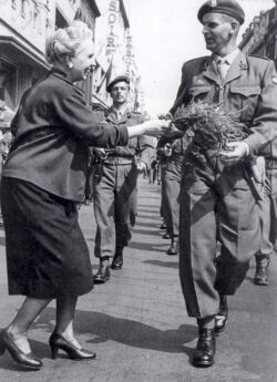 A captain of 1 Para Bn receives a bouquet from a well-wisher during their parade after returning from the Congo in 1960.