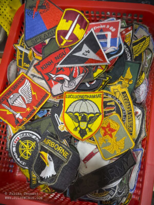 Dan Sinh War Surplus Market. March 2026. Various FAKE Vietnam War unit patches. In 2012, these same patches could be bought for as little as US$1 each. Now the asking price is US$4 each. Photo: Julian Tennant Dan Sinh War Surplus Market
