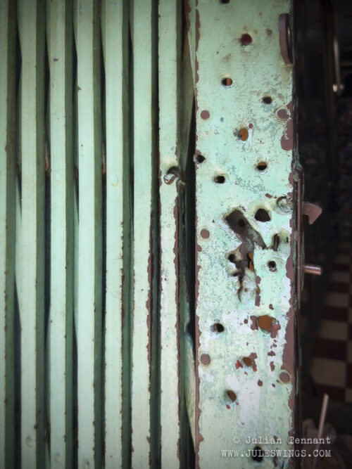 Scars of Tet 1968. Bullet and shrapnel holes on the exterior gate of the house.