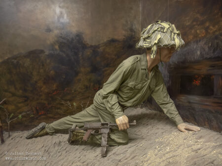 Display honouring Comrade Phan Đình Giót who used his body to cover a gun port at Beatrice on March 13, 1954. During the assault, the French bunker was stalling the Viet Minh advance. Badly wounded, Phan Đình Giót crawled forward and hurled himself against the bunker's firing slit (loophole) to block the weapon's line of sight and fire, allowing his comrades to rush the fortification and destroy it.He was posthumously recognized as one of the 16 official Heroes of the People's Armed Forces for exceptional bravery during the campaign. Photo: Julian Tennant Dien Bien Phu Victory Museum