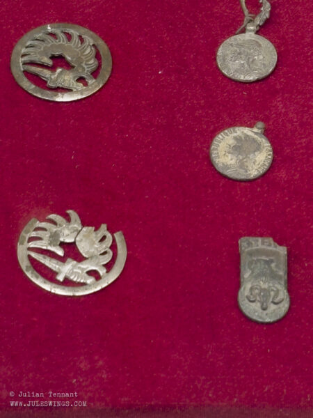 French relics recovered from the battlefield, including two parachutist beret badges, medallions and the insignia of 5e Bataillon de Marche du 7e Régiment de Tirailleurs Algériens, or 5/7e RTA which was tasked with defending Gabrielle. Photo: Julian Tennant Dien Bien Phu Victory Museum